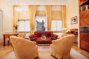 uma sala de estar com um sofá, uma mesa e cadeiras em Ventana Hotel Prague em Praga