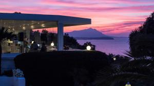 a building with a view of the ocean at sunset at Hotel Cala Moresca in Bacoli