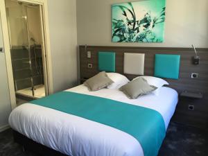 Schlafzimmer mit einem großen Bett mit blauer und weißer Bettwäsche in der Unterkunft Hotel-Restaurant St-Christophe in Belfort