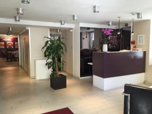 a lobby with a potted plant and a counter at Hotel-Restaurant St-Christophe in Belfort