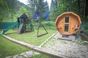 a small playground with a slide and a play house at Chata Lopušná dolina in Lučivná