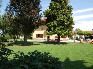 a house with two trees in a yard at Cascina la Barona in Savigliano