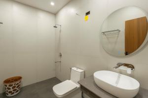 a bathroom with a white toilet and a mirror at Konnect Inn-New Delhi Railway Station in New Delhi +14 photos