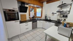 a kitchen with white cabinets and a black counter top at Ferienwohnung Casa Karin mit Sauna in Bodman-Ludwigshafen +32 photos