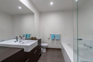 a bathroom with a sink and a toilet and a shower at Coastal Comfort, Just a Ocean Glimpse Away Torquay in Torquay +33 photos