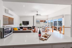 a kitchen and living room with white counter tops at Coastal Comfort, Just a Ocean Glimpse Away Torquay in Torquay