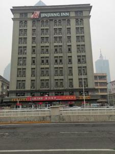a large building with a sign on top of it at Jinjiang Inn Tianjin Station Jinwan Square in Tianjin