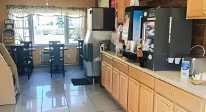 a kitchen with a counter and a table in it at Travelodge by Wyndham Bay Shore Long Island in Bay Shore