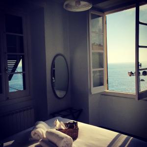 カモーリにあるAl Piccolo Scoglio - Room & Breakfastのベッドルーム1室(ベッド1台、鏡、窓付)