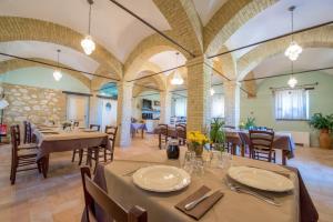 comedor con mesas y sillas y techos abovedados en Casale Rotoloni, en Protte