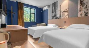 a hotel room with two beds and blue walls at Jinjiang Inn Wenzhou Shuangyu The Terminal in Jiangjunqiao +191 photos