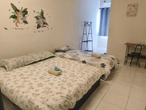 Dos camas individuales en un dormitorio con escritorio. en ForgetMeNot Pangkor Homestay 70 小蓝花の民宿, en Pangkor