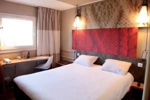 
A bed or beds in a room at ibis Paris Le Bourget
