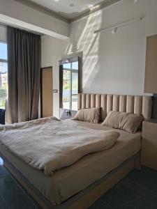 un grand lit dans une chambre avec une grande fenêtre dans l'établissement Shree Vallabh Resort, à Nathdwara 65 autres photos