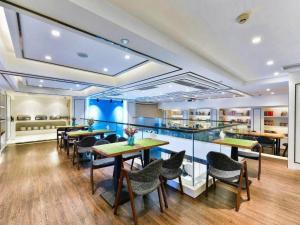 a restaurant with tables and chairs in a room at Xana Hotelle Chengdu East Railway Station Kaide Plaza in Chengdu