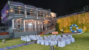 un groupe de chaises blanches devant un bâtiment dans l'établissement Shree Vallabh Resort, à Nathdwara