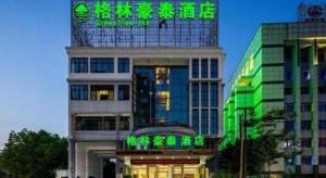 un edificio con una señal verde encima en GreenTree Inn Hefei Government Cultural District South District Provincial Hospital Nanqu Hotel, en Hefei