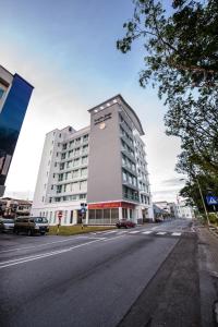 - un grand bâtiment blanc dans une rue de la ville dans l'établissement Keoja Hotel, à Kuala Belait