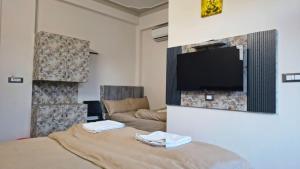 a room with a bed and a tv on a wall at Shree Vallabh Resort in Nāthdwāra