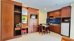 a kitchen with wooden cabinets and a table with a sink at Baan Sudarat Hotel in Patong Beach