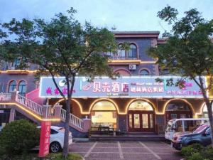 a building with a sign on the front of it at Shell Zaozhuang Taierzhuang Ancient City East Gate Hotel in Yanzibu