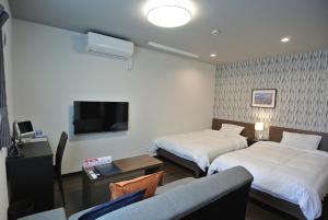 a hotel room with two beds and a tv at SA Inn 伊那ナイスロード in Wada