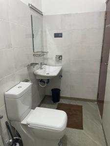 a bathroom with a white toilet and a sink at Moon Town in Aluthgama