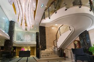 a lobby with stairs and a chandelier at Empress Hotel Ho Chi Minh City in Ho Chi Minh City