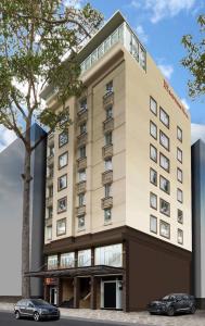 a hotel with two cars parked in front of it at Empress Hotel Ho Chi Minh City in Ho Chi Minh City