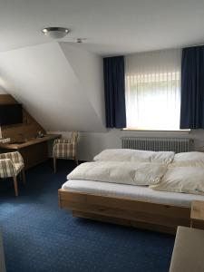 1 Schlafzimmer mit 2 Betten, einem Schreibtisch und einem Fenster in der Unterkunft Hotel Neuenburger Hof in Neuenburg