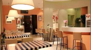 a restaurant with chairs and tables and a bar at Jinjiang Inn Dalian Development Zone Jinma Road Light Railway Station in Jinzhou