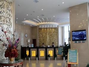 eine Lobby eines Hotels mit zwei Personen an der Theke in der Unterkunft GreenTree Inn Jiangxi Nanchang XianGYAng Road Lianxi Road Business Hotel in Nanchang County