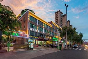 a building on the side of a city street at GreenTree Inn Hainan Haikou Jinniu Road Business Hotel in Haikou