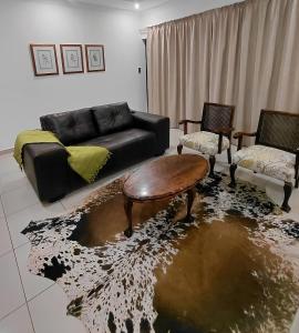 ein Wohnzimmer mit einer Couch und einem Tisch und Stühlen in der Unterkunft Agapantha Cottage in Ezulwini