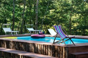 2 sillas de jardín sentadas en una piscina en La Casa nel Bosco, en Civitella in Val di Chiana