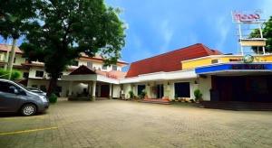 a car parked in front of a building at Puri Mega Hotel in Jakarta