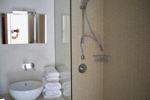 ein Badezimmer mit Waschbecken und Dusche mit Handtüchern in der Unterkunft Aphrodite Samos Suites in Marathokampos