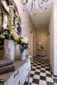 - un couloir avec des fleurs dans des vases sur une commode dans l'établissement La Casona de Nené, à Arzúa