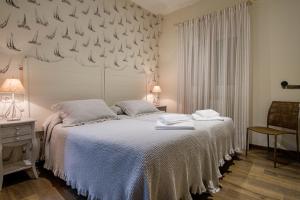 - une chambre avec un lit doté d'un couvre-lit blanc dans l'établissement La Casona de Nené, à Arzúa