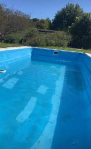 a pool of blue water with trees in the background at Casa Valle Verde in Sierra de los Padres