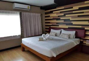 a bedroom with a bed with two white towels on it at Day Hotel Khon Kaen in Khon Kaen