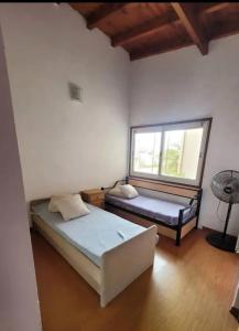 a bedroom with two beds and a window at Casa Valle Verde in Sierra de los Padres