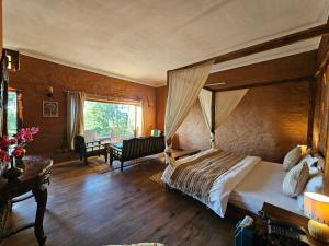 une chambre avec un grand lit à baldaquin dans l'établissement ilika Resort, Pauri, à Pauri