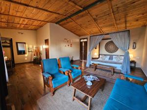a living room with a bed and blue chairs at ilika Resort - A Boutique Stay 30 km from Devprayag in Pauri +76 photos
