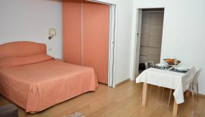 a small bedroom with a bed and a table at Belisario Fiera Milano Apartment in Milan