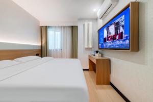 a bedroom with a bed and a flat screen tv at An Yi Hotel in Beijing