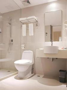 a white bathroom with a toilet and a sink at City Comfort Inn Hengyang Dayang Department Lianhu Plaza in Hengyang