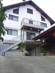 DrăgăneasaにあるCasa RiAnの階段とバルコニー付きの白い建物