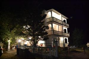 a large white house with a balcony at night at Apartmani Jenny i Tania in Lopar