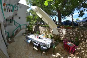 a table and chairs with an umbrella on a patio at Apartmani Jenny i Tania in Lopar